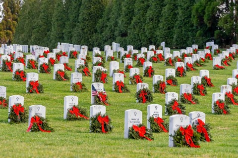 Atop a hill, a veterans cemetery with white headstones and the American flag evokes deep honour,