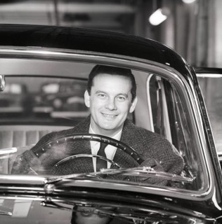 Driving in the 1960s. A man behind the steering wheel in his car looks happy. Sweden 1960.
