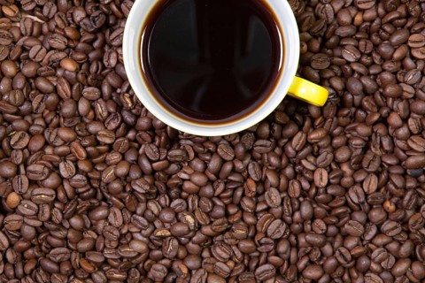 Cup of coffee and coffee beans on a table