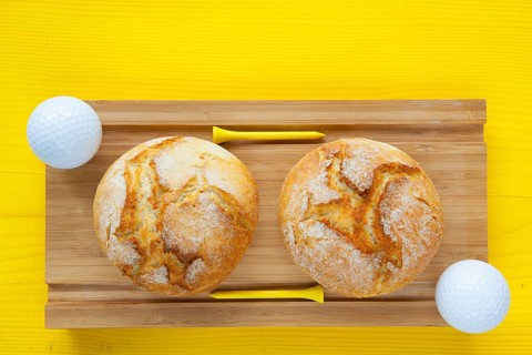Golf breakfast - Two wheat bread and golf balls on wooden desk