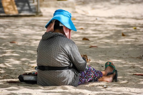 Balinese woman resting quietly on the beach, enjoying the peaceful atmosphere