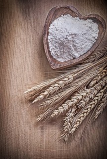 Wooden bowl with flour golden rye wheat ears on wood board