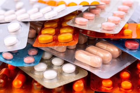 Different colorful capsules and pills in plastic packs - blisters stacked. Global pharmaceutical