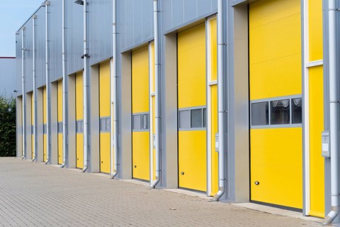 Exterior of a commercial warehouse with yellow roller doors