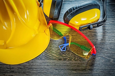 Building helmet goggles earmuffs on wooden board