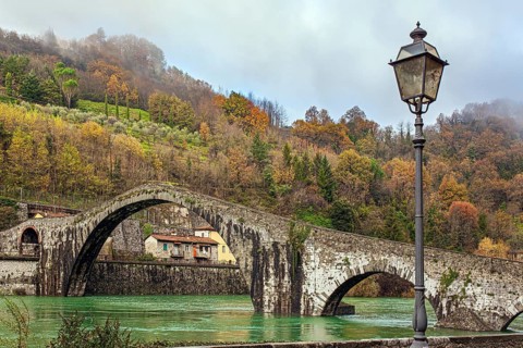 Picturesque stone Devil's Bridge over the Serchio River. Medieval bridge of magnificent