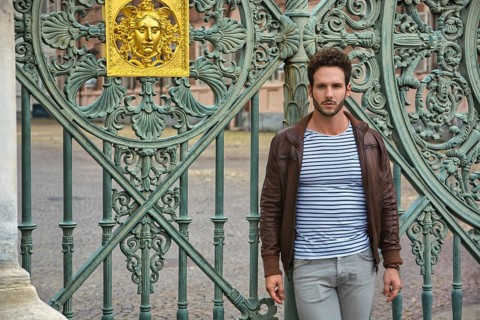 A man standing in front of a green gate in Piazza Castello in Turin, Italy, Europe