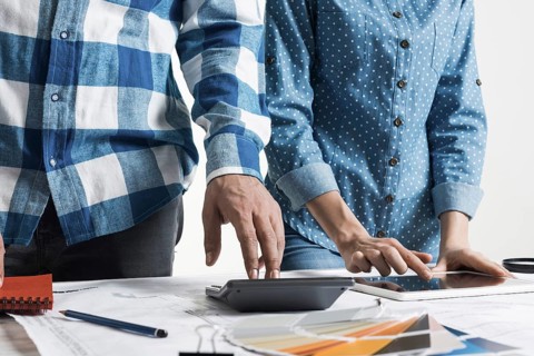 Designers working with color swatches and tablet computer at desk. Interior design, architectural