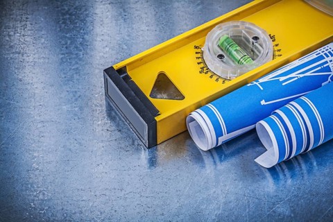 Blue engineering drawings construction level on metallic background maintenance concept