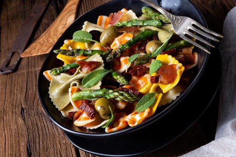 Pasta salad with green asparagus, olives and Parma ham