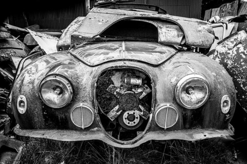 Antique cars on a big scrapyard at the end of Old Coach Road Trail, North Island of New Zealand