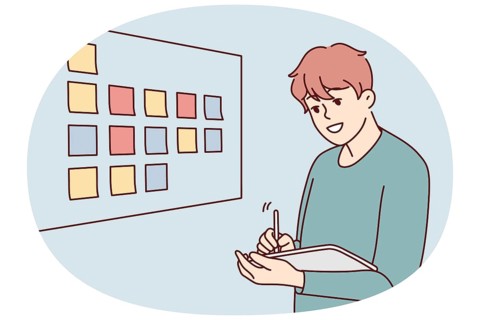 Motivated businessman brainstorm wok with sticky notes on board in office. Male employee or worker
