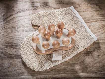Massager body scrubber on wooden board healthcare concept