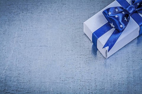 Packed box-container with bow on metallic background celebrations concept