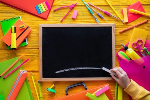 Back to school supplies arrangement vivid colorful neon color and blackboard hand chalk