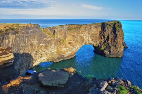 The cape Dirkholaey in the south of Iceland. The enormous rock elephant it is lit with a summer.