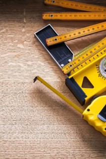 Oak board with wooden meter measuring tape construction level and square ruler construction concept