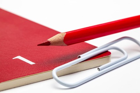 Organizer for the month of January, red pencil and white paperclip on the white table