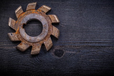 Vintage milling cutter with cogs on wood board construction concept