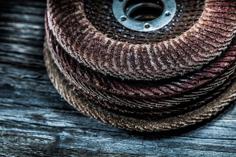 Pile of rotary abrasive discs on wooden board