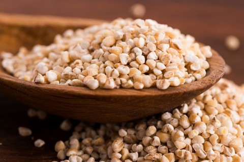 Barley groats on wooden spoon
