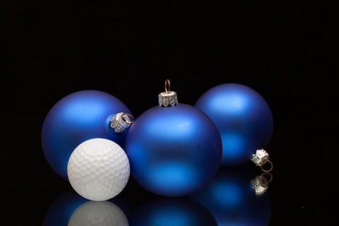 Blue Christmas decoration a golf balls on a black glass desk