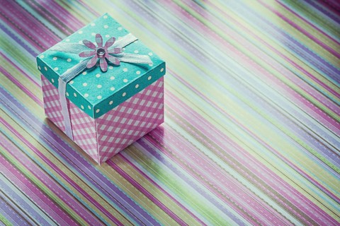 Wrapped gift box on stripy fabric background celebrations concept