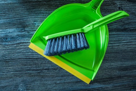 Plastic dustpan and brush set on wooden board