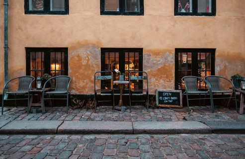 Outdoor cafe seating on cobblestone street with warm lighting and a rustic atmosphere in central