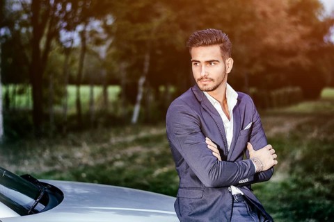 Portrait of young attractiave man in white shirt leaning on his new stylish polished car outdoor