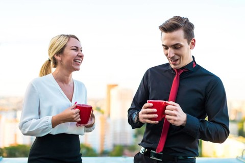 Couple of caucasian businessmen, young attractive brunette man in dark suit, red tie and black