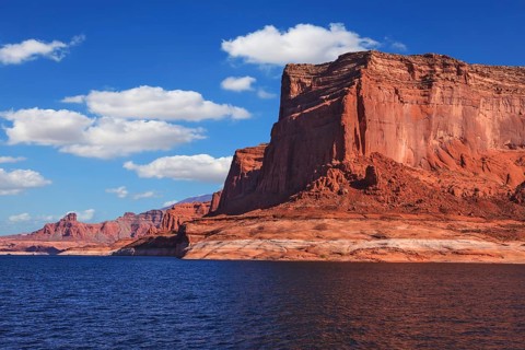 Lake Powell is surrounded by magnificent red hills. Scenic huge artificial water basin of the