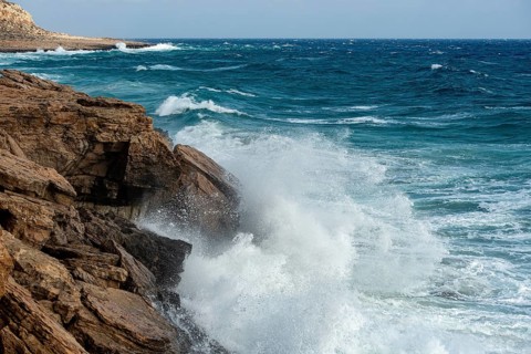 Waves crashing on rocky coast. Windy weather, Powerful sea waves braking on rocks