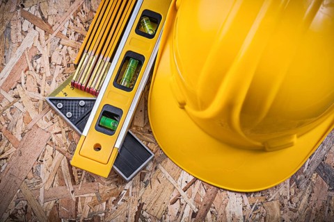 Square ruler construction level hard hat wooden meter on OSB