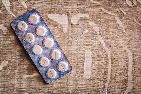 Pills in blister pack on vintage wooden board with organized copyspace medical concept