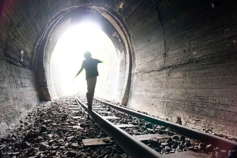 Child walking in railway tunnel. Vintage clothes