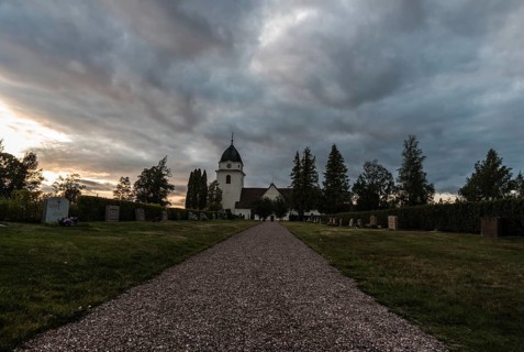 Rattvik, Dalarna, Sweden, 08 05 2019: View over the cloudes graveyard and the small church at dusk,