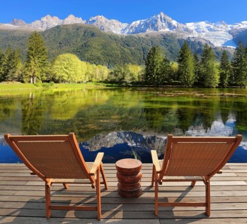 Comfortable lounge chairs on wooden platform for rest and observation. City park in the Alpine