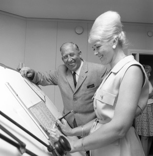 Chocolate in the 1960s. A woman in an office has her hair in the typical Beehive hairstyle, in