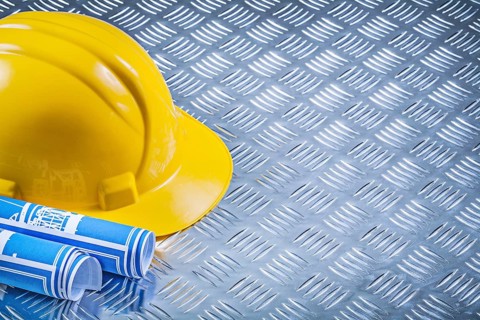 Blue engineering drawings building helmet on corrugated metal background construction concept