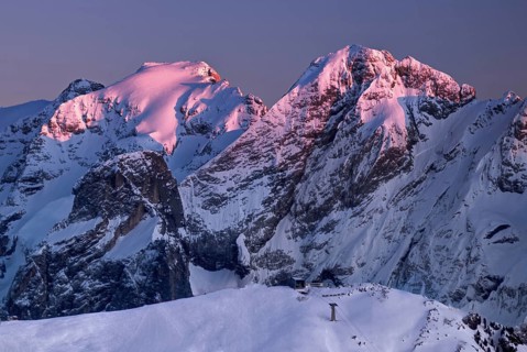View from the top of Marmolada on the surrounding Dolomite hills after sunrise in winter