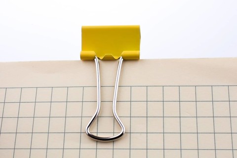 Colored paper clip on a checked notebook page