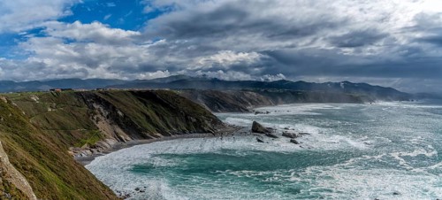 A panorama view of the rugged cliffs and coastline at Cabo Vidio in Asturias under an expressive