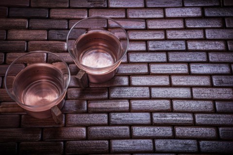 Coppery teacups on wooden mat Food and drink concept