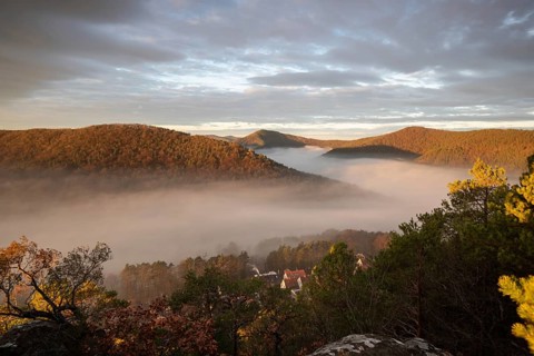 Mystical sunrise at the Wachtfelsen. Fascinating landscape shot between fog and clouds near
