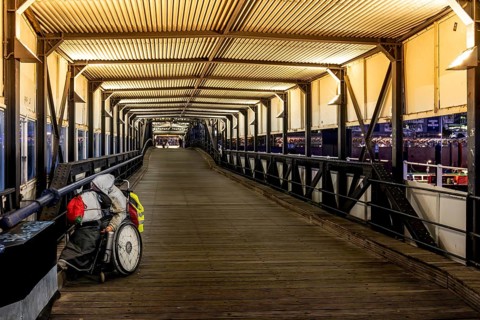 Homeless man in wheelchair in Überseebrücke, evening light, harbour, Hamburg, Germany, Europe