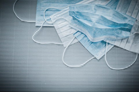 Horizontal image of disposable face masks on a striped background