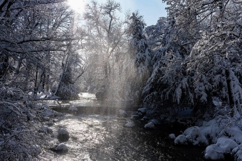 Waterfall at the Eisbach, winter with snow in the southern part of the English Garden, Munich,