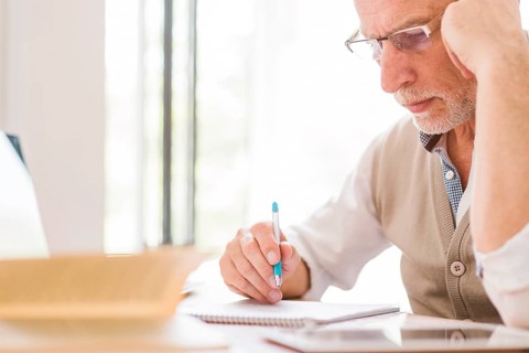 Senior professor glasses writing notebook classroom