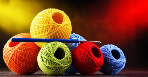 Composition with assortment of different colored yarns and hook for crocheting